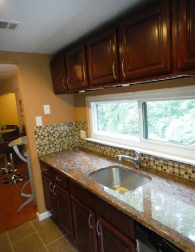 A kitchen with brown cabinets and granite counter tops.