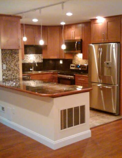 A kitchen with stainless steel appliances and wood floors.