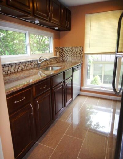 A kitchen with brown cabinets and a window.