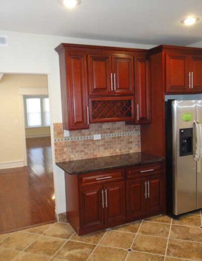 A kitchen with brown cabinets and a stainless steel refrigerator.
