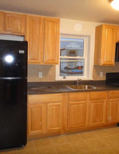 A kitchen with black appliances and wooden cabinets.