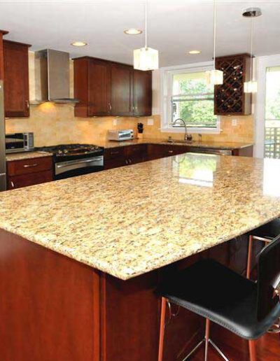 A kitchen with a granite counter top and stainless steel appliances.
