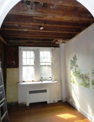 An empty room with wooden walls and a window.